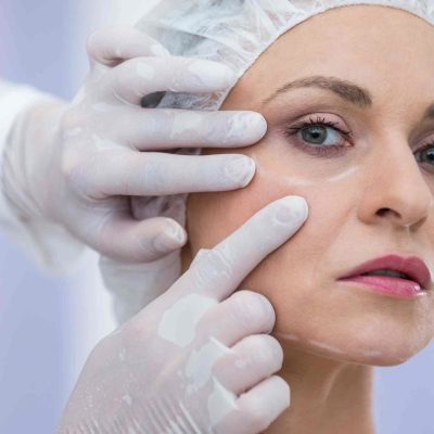 Close-up of doctor examining female patients face for cosmetic treatment